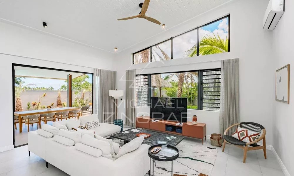 Intérieur de la Villa Clusia à Tamarin Intérieur moderne d'une villa avec salon lumineux et baies vitrées, vue sur la nature.