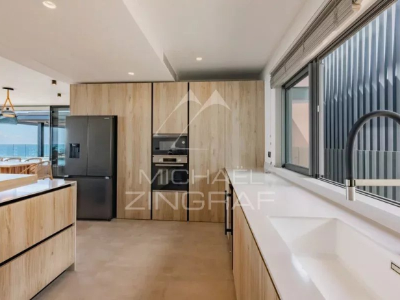 Cuisine moderne d'un appartement avec vue sur l'océan, équipée et lumineuse.