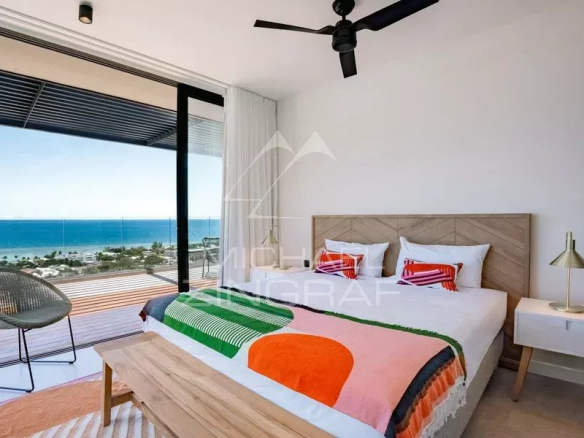 Chambre d'appartement avec vue sur l'océan Indien, décor moderne et terrasse.