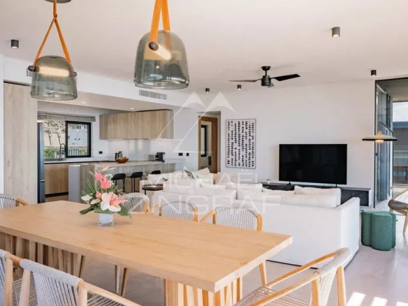 Intérieur d'un appartement moderne avec salle à manger, salon et cuisine ouverte, vue sur l'océan