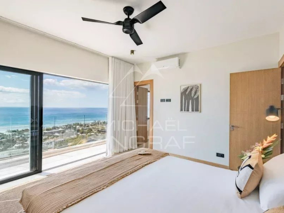 Chambre d'appartement avec vue sur l'océan et le Morne, décor moderne et lumineux.