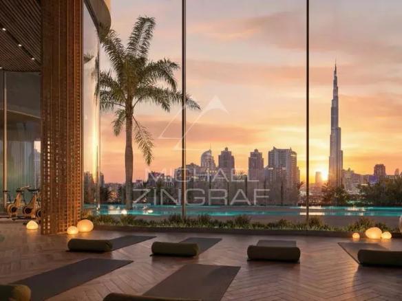 Intérieur d'un appartement de luxe à Dubaï avec vue sur la ville et le Burj Khalifa au coucher du soleil.
