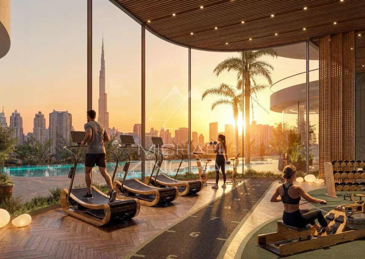 Salle de sport dans une résidence de luxe à Dubaï Intérieur d'une résidence de luxe à Dubaï avec salle de sport et vue sur la ville au coucher du soleil.