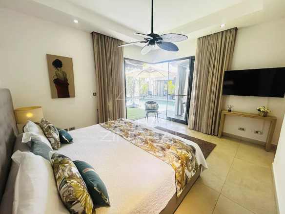 Room in a modern villa in Pereybère with double bed, elegant decor and access to a garden.
