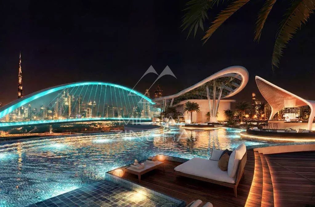 Piscine d'un appartement de luxe à Dubaï avec vue sur la ville illuminée la nuit.