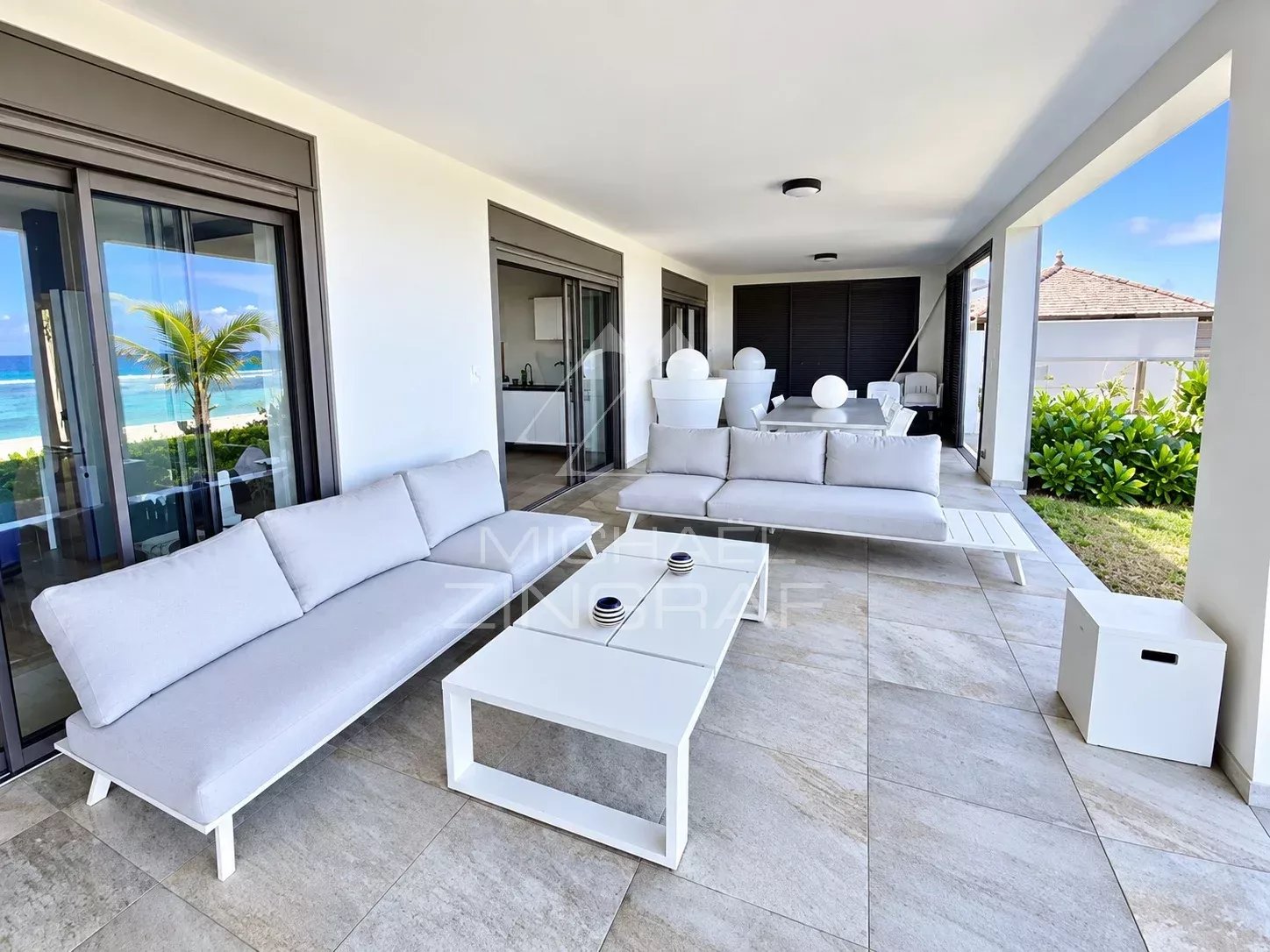 Terrasse d'un appartement avec vue sur le lagon, mobilier moderne et espace de vie extérieur à Saint-Pierre.
