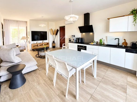 Intérieur d'un appartement moderne avec salon et cuisine ouverte.