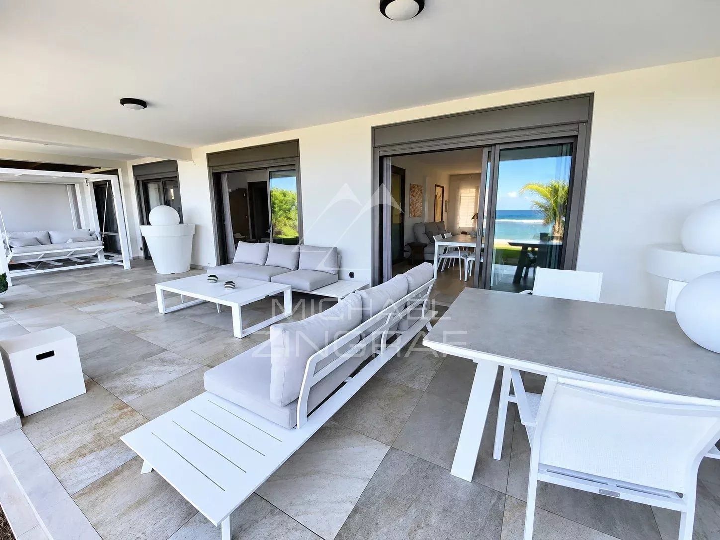 Terrasse d'un appartement avec mobilier moderne et vue sur le lagon à Saint-Pierre.