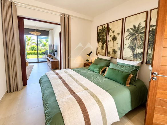 Chambre d'un appartement avec lit double et décoration tropicale à Saint-Pierre.