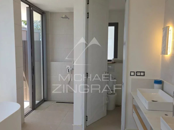 Salle de bain moderne avec douche et lavabo, en cours de construction dans une villa à Mont Choisy Golf.