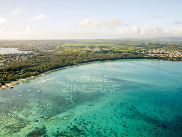 Vue aérienne de la baie de Mont Choisy à Grand Baie, montrant la mer turquoise et la végétation environnante.