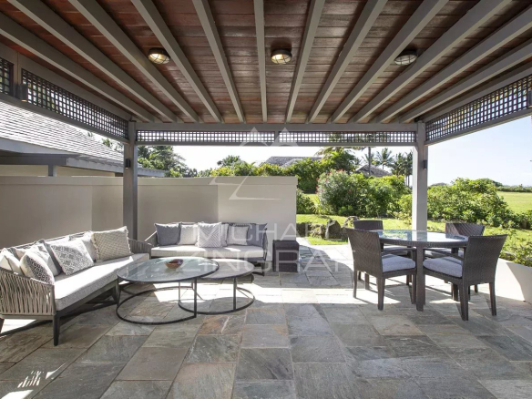 Terrasse d'une villa à Beau Champ, avec mobilier extérieur et vue sur le jardin.