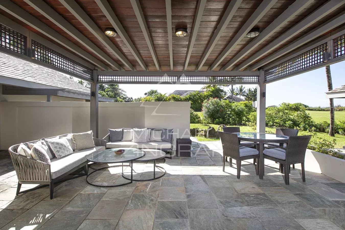 Terrasse de la Villa Lunea Terrasse d'une villa à Beau Champ, avec mobilier extérieur et vue sur le jardin.