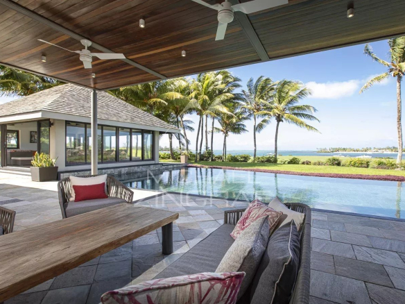 Vue panoramique d'une villa avec piscine surplombant le lagon et le golf à Beau Champ, Île Maurice.
