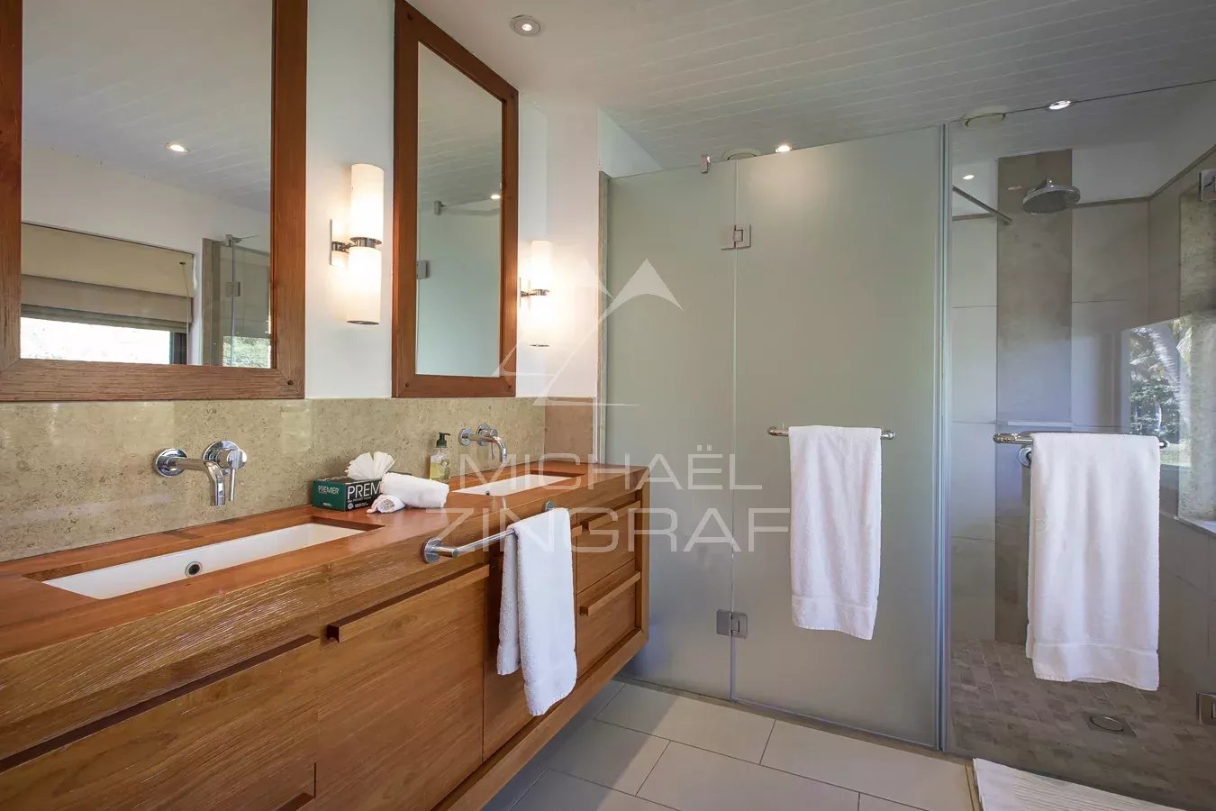 Salle de bain de la Villa Lunea Salle de bain moderne avec lavabo en bois et douche vitrée dans une villa à l'Ile Maurice.