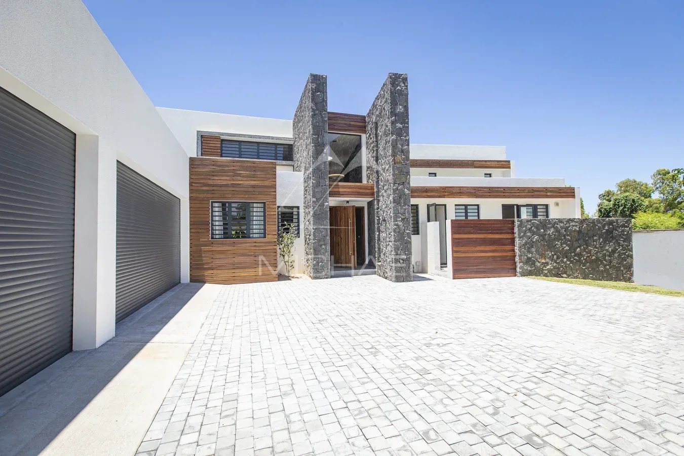 Luxury villa in Haute Rive Modern villa with stone and wood facade, paved driveway in Haute Rive.
