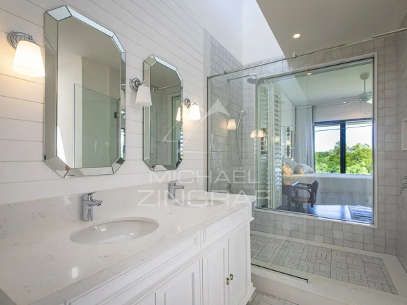Modern bathroom with double sink and glass shower in a luxury villa.