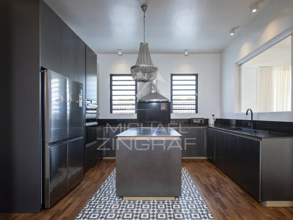Cuisine moderne avec îlot central dans une villa de prestige à Haute Rive.