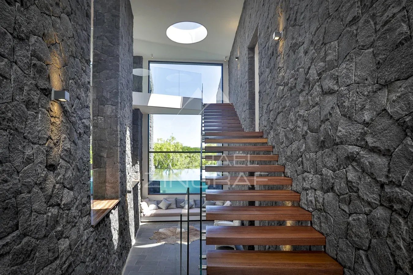 Intérieur d’une villa à Haute Rive Intérieur d'une villa moderne avec escaliers en bois et murs en pierre à Haute Rive.