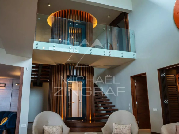 Intérieur d'une propriété moderne avec un escalier et des espaces ouverts à Rivière Noire, Île Maurice.