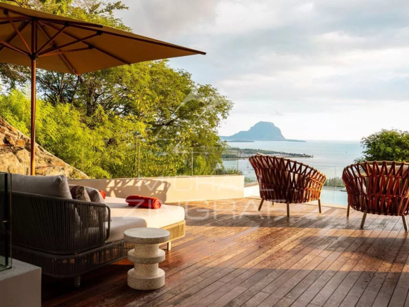 Vue panoramique sur l'océan et le Morne Brabant depuis une terrasse à Rivière Noire, Île Maurice.