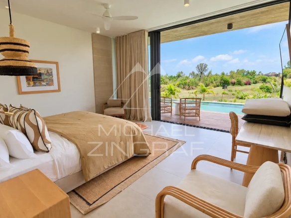 Modern room with pool and garden view in a villa in Beau Champ.