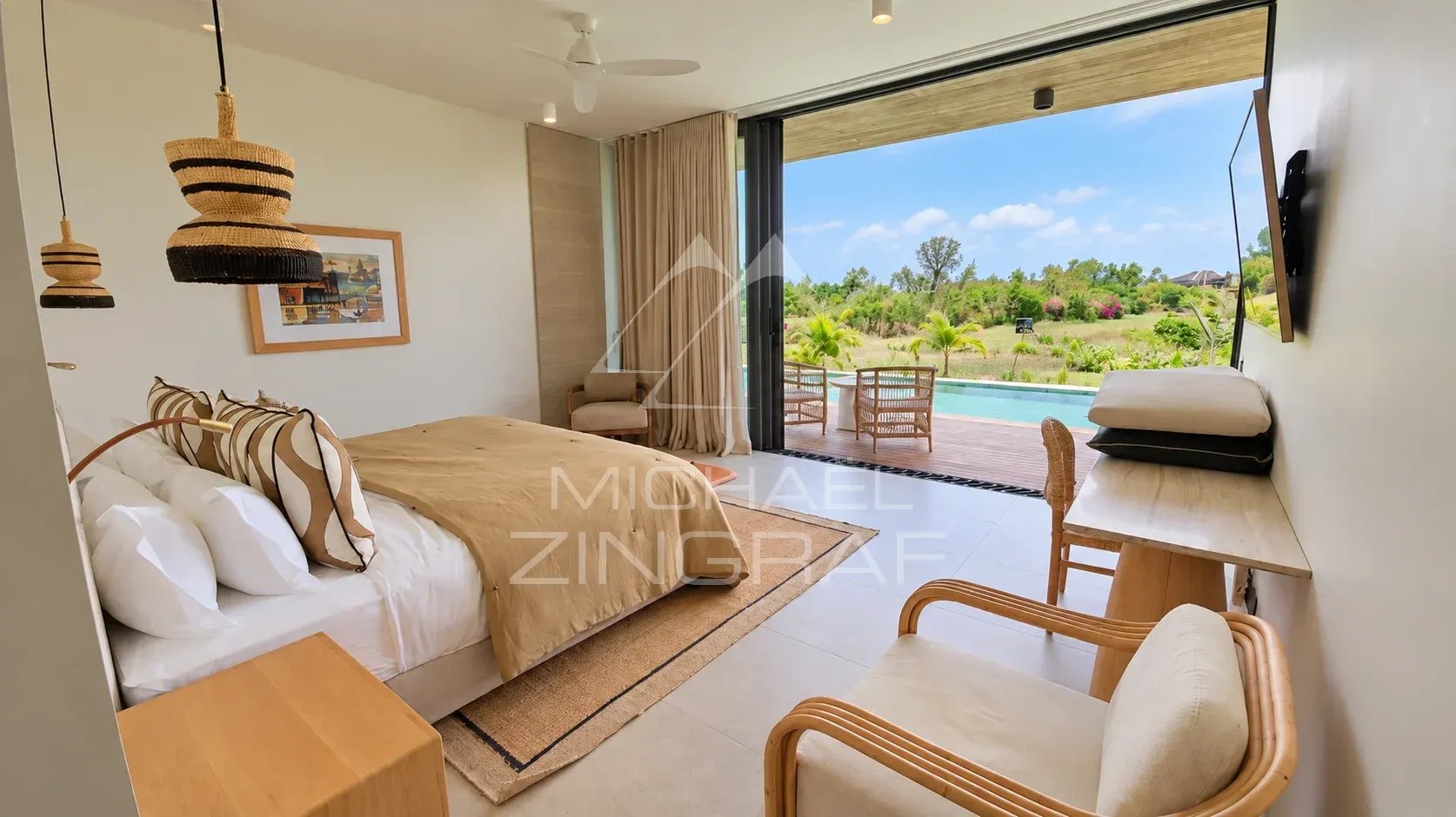 Modern room with pool and garden view in a villa in Beau Champ.