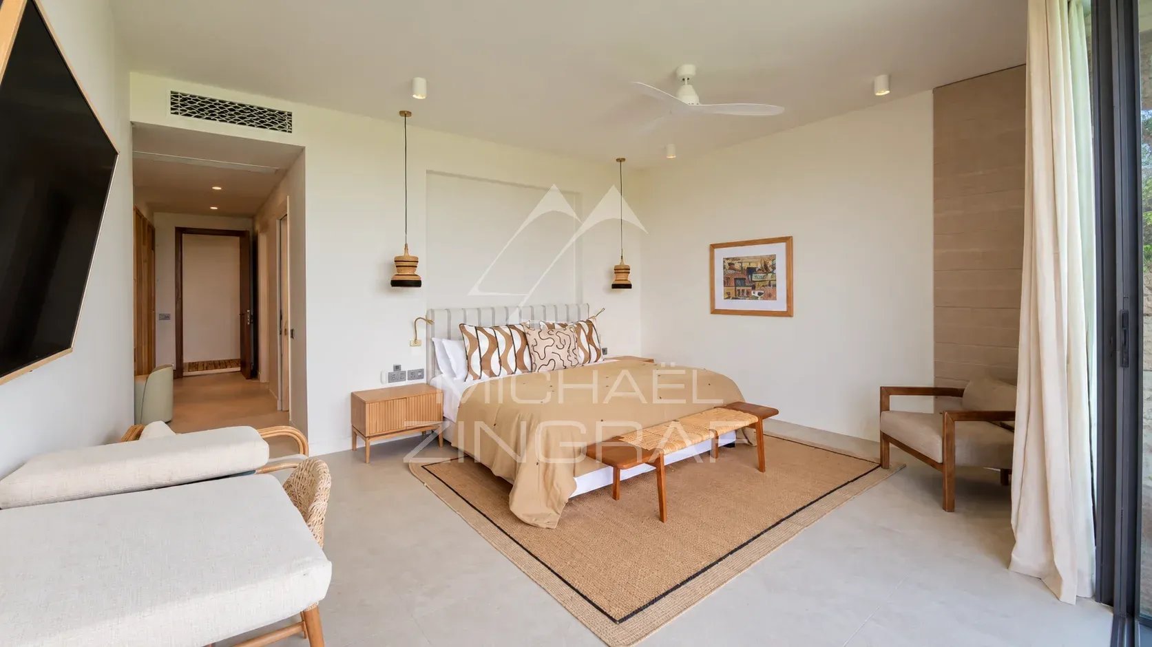 Bedroom in a contemporary villa with bed, armchairs and modern decor.