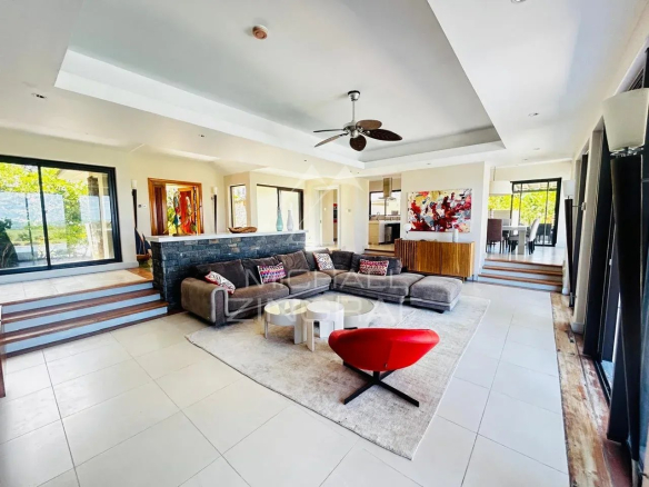 Intérieur d'une villa moderne avec salon spacieux et vue sur le golf à Beau Champ.