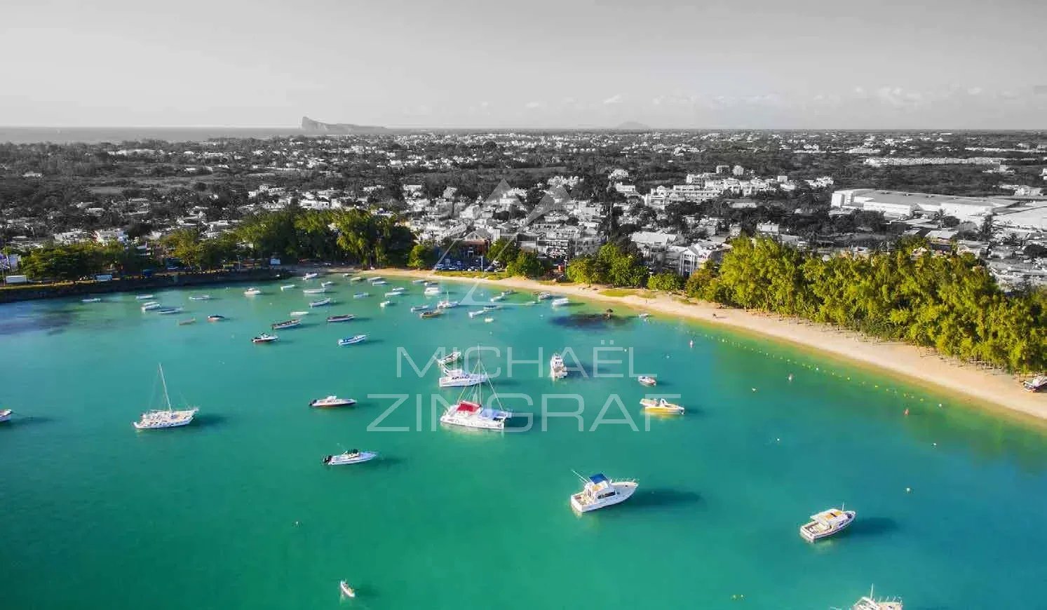 Vue de Grand Baie Vue aérienne de Grand Baie avec des bateaux dans l'eau turquoise et des plages de sable.