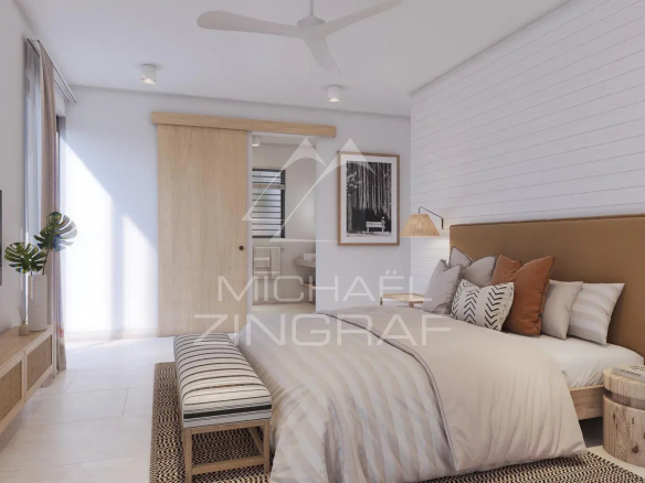 Chambre d'une villa moderne avec lit, télévision et décoration minimaliste.