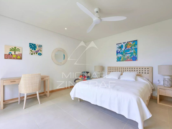 Chambre d'une villa avec lit double, bureau et décoration tropicale à Grand Baie.