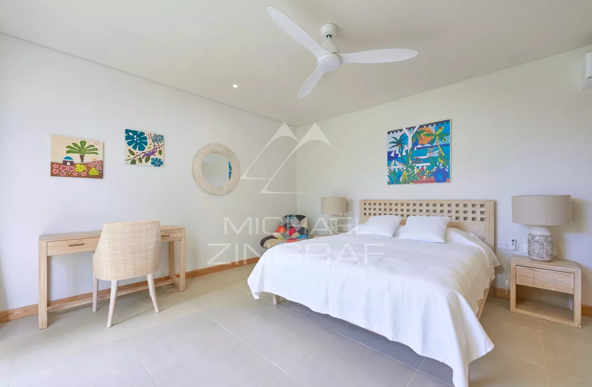 Chambre d'une villa avec lit double, bureau et décoration tropicale à Grand Baie.