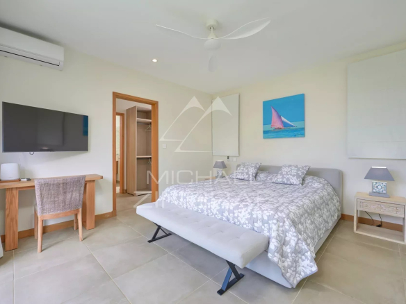 Chambre spacieuse avec lit double, bureau et télévision dans une villa à Grand Baie.