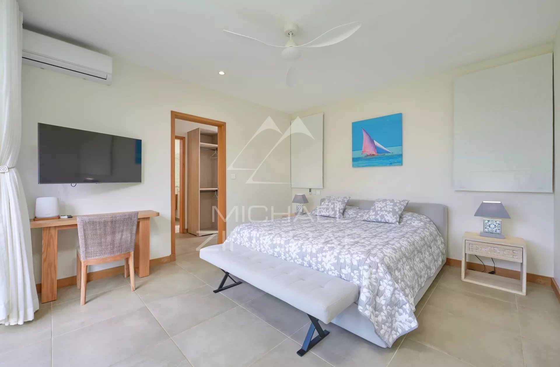 Chambre spacieuse avec lit double, bureau et télévision dans une villa à Grand Baie.