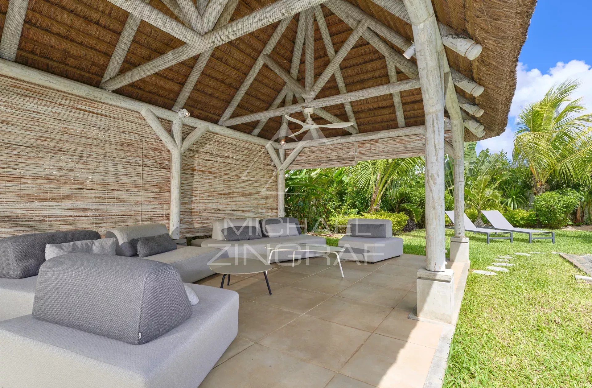 Terrasse couverte avec mobilier moderne dans un jardin tropical à Grand Baie