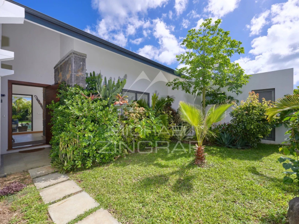 Jardin tropical avec pelouse et plantes devant une villa moderne à Grand Baie.