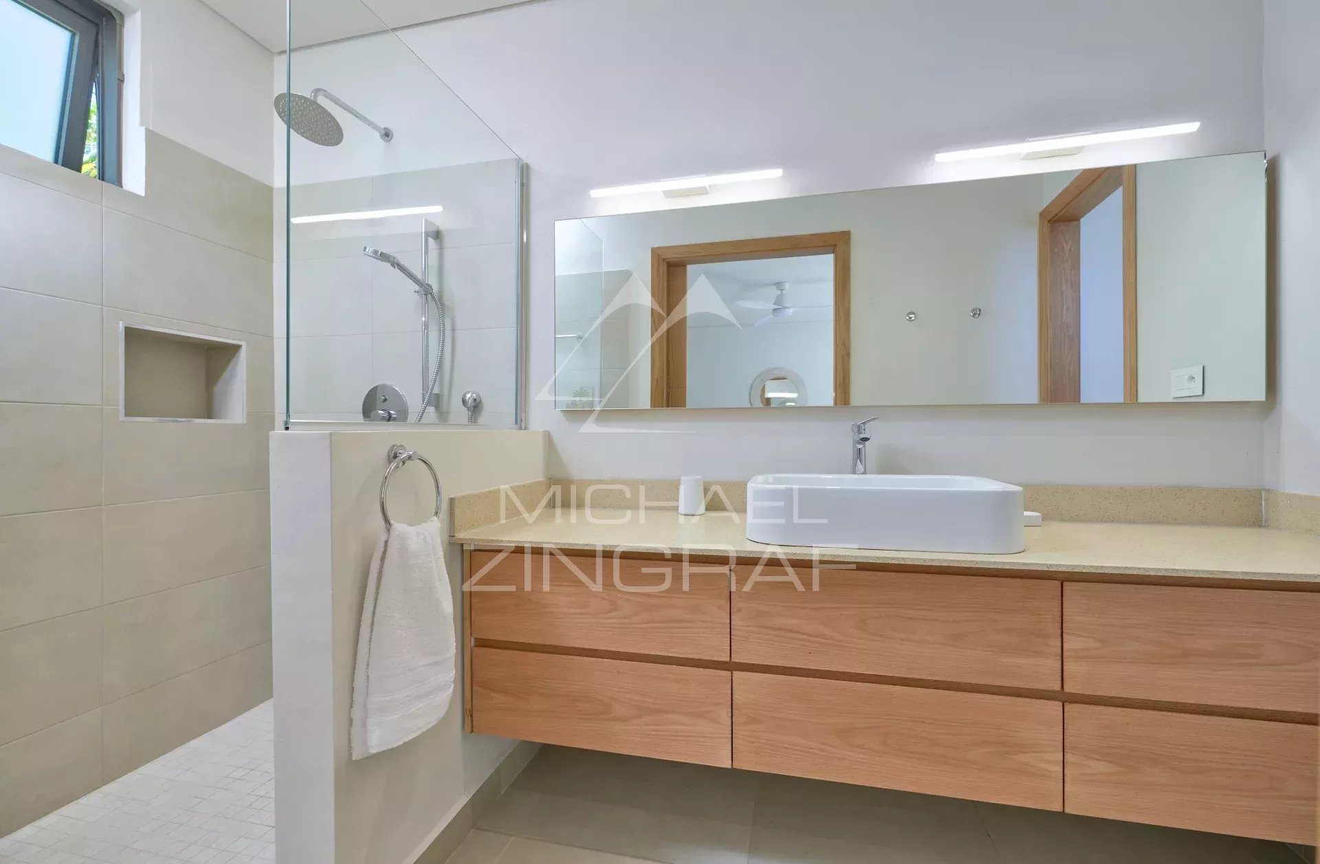 Salle de bain moderne avec douche et lavabo dans une villa à Grand Baie.