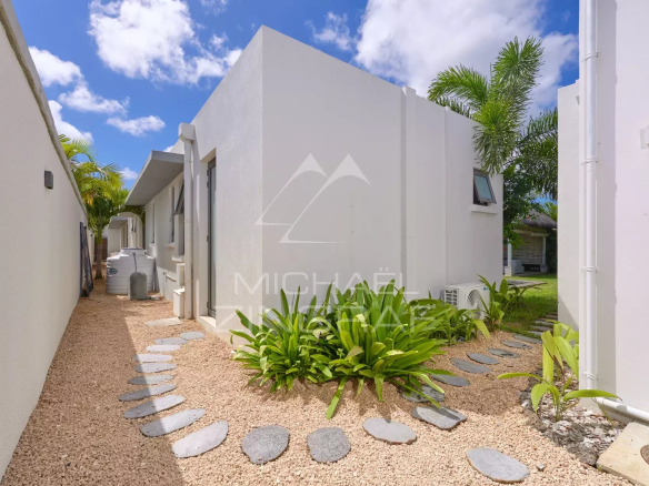 Allée menant à une villa moderne avec jardin tropical à Grand Baie.