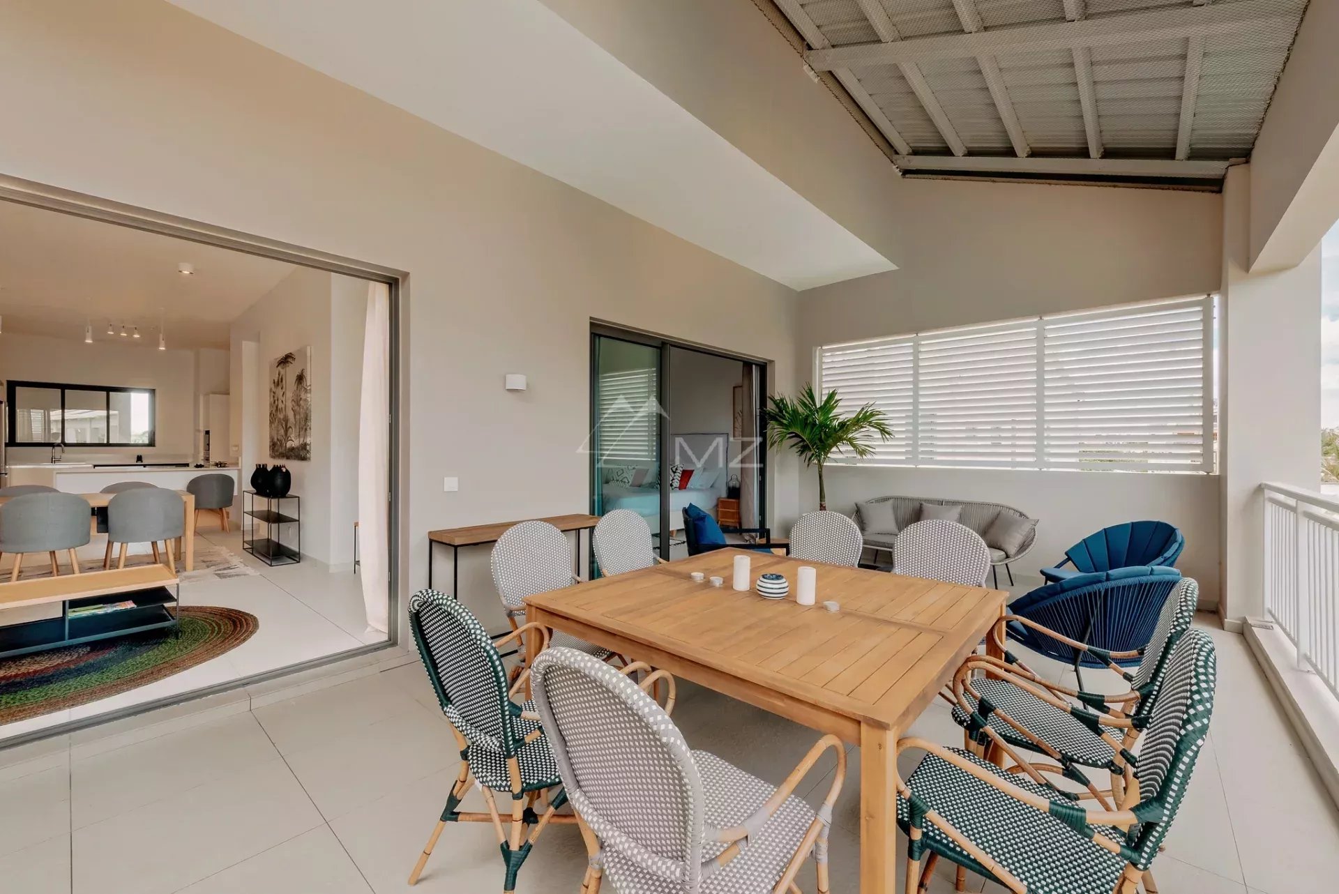 Penthouse avec vue mer à Pereybere Terrasse d'un penthouse avec vue mer à Pereybere, Ile Maurice, mobilier en bois et chaises confortables.