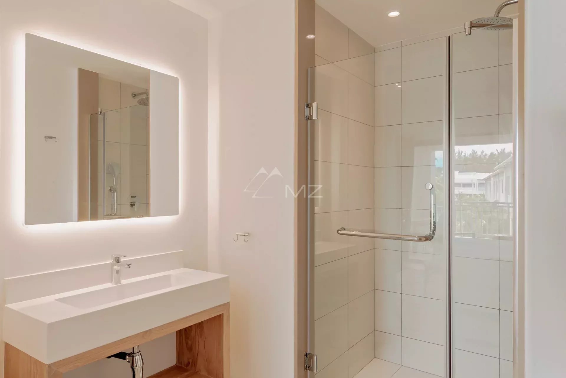 Salle de bain du penthouse à Pereybere Salle de bain moderne avec douche et miroir éclairé dans un penthouse à Pereybere, Ile Maurice.