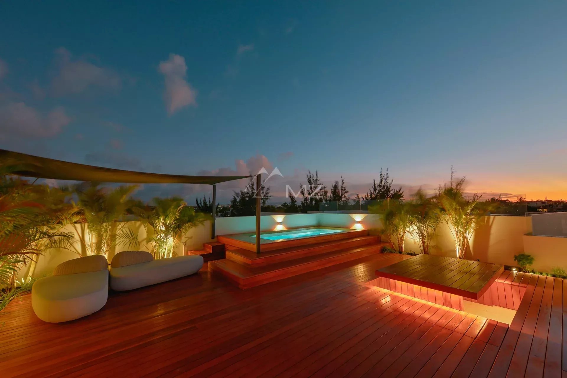 Penthouse à Pereybere avec vue mer Penthouse avec piscine et terrasse en bois à Pereybere, Île Maurice, au crépuscule.