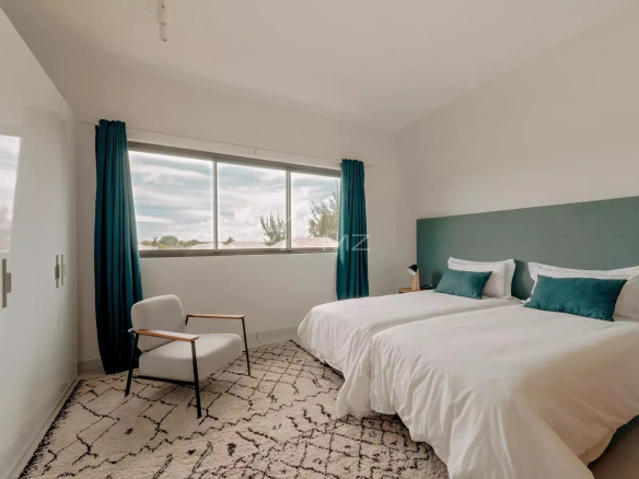 Chambre d'un penthouse à Pereybere, Ile Maurice, avec deux lits et une fenêtre donnant sur l'extérieur.