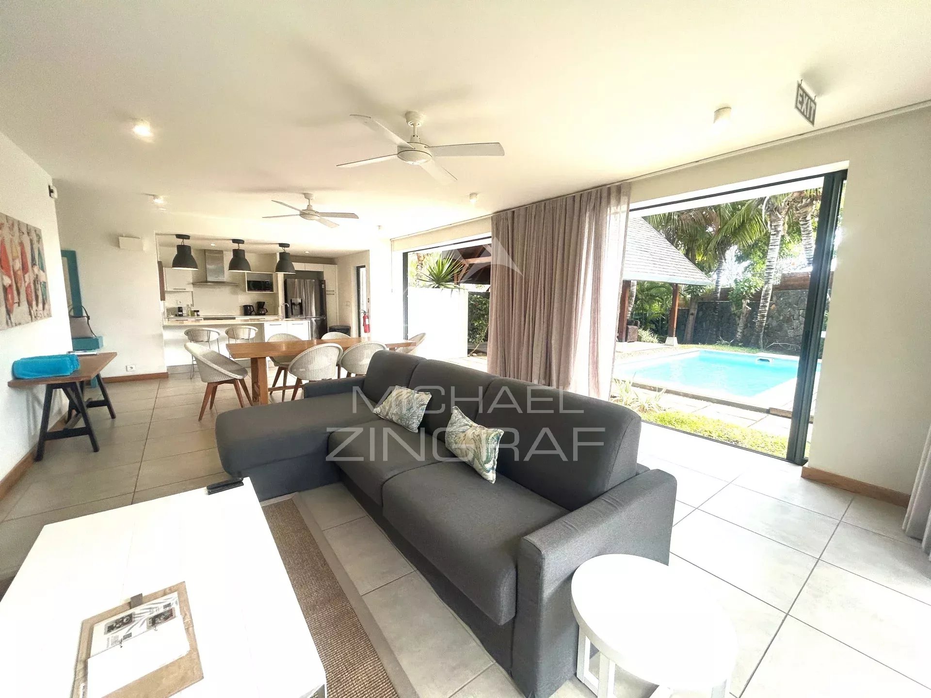 Intérieur d’une villa à Marguery Villas Intérieur d'une villa avec salon, cuisine et accès à la piscine extérieure.