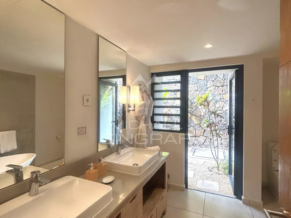 Salle de bain moderne avec lavabo et accès à un jardin extérieur