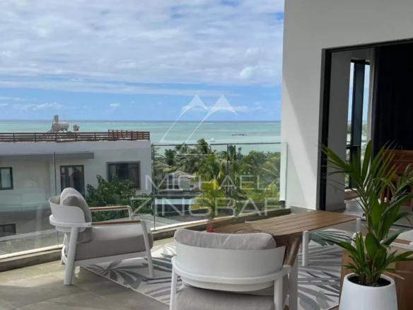 Terrasse d'un penthouse avec vue sur la mer à Haute Rive, mobilier moderne et plantes.
