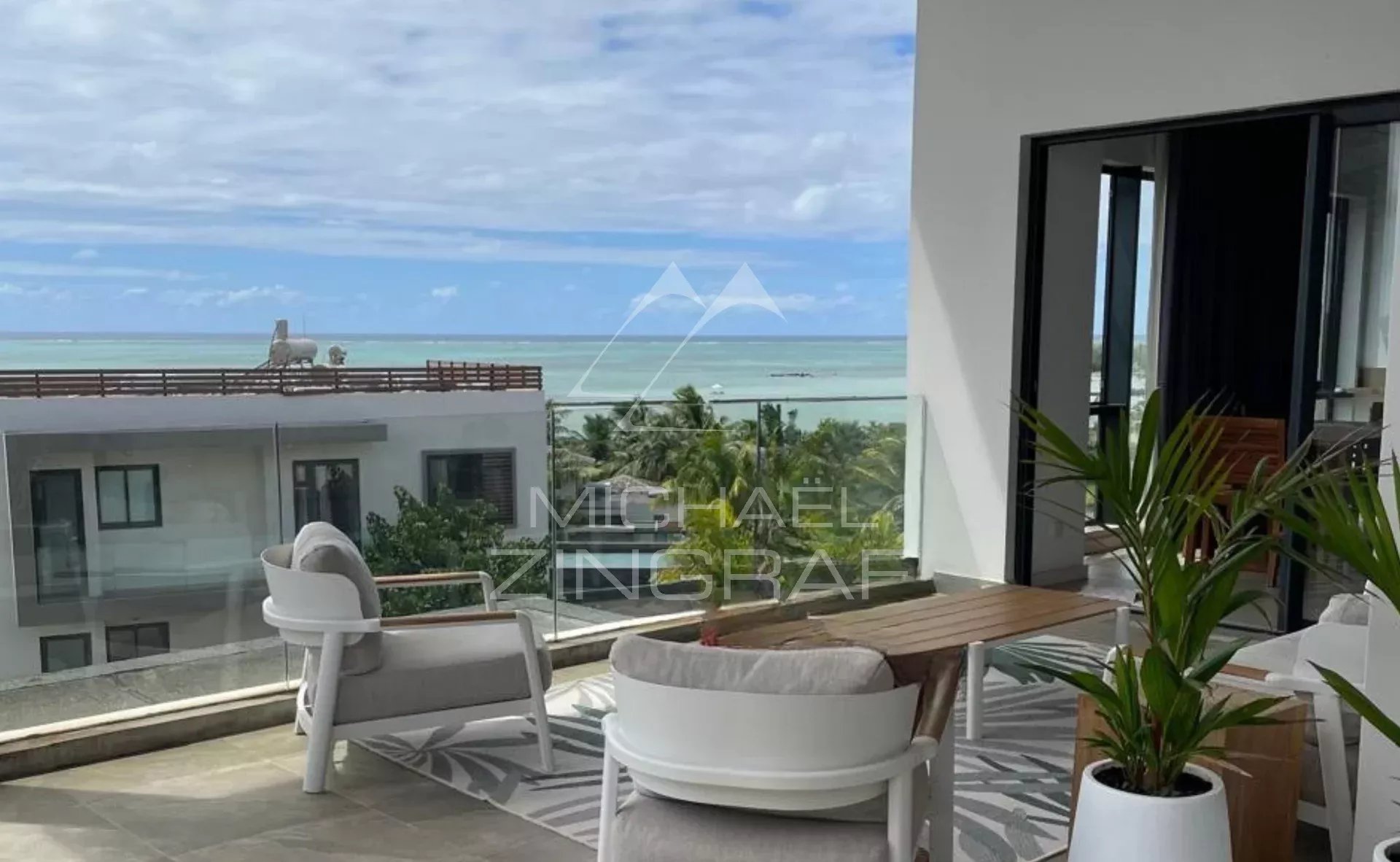 Terrasse d'un penthouse avec vue sur la mer à Haute Rive, mobilier moderne et plantes.