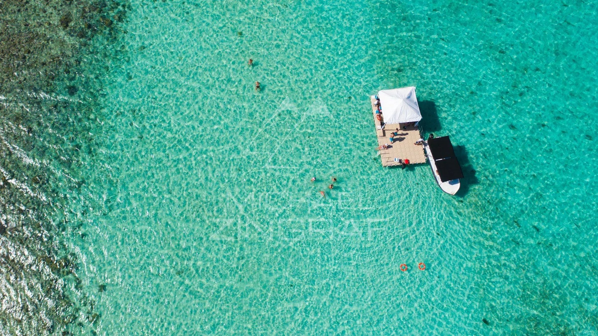Vue aérienne d'un ponton avec des personnes et un bateau sur une mer turquoise