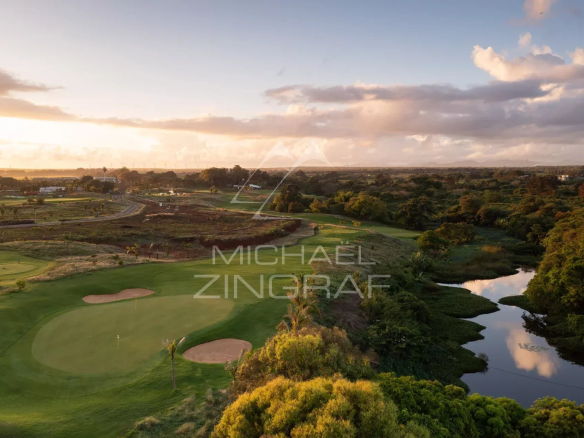 Vue panoramique sur un terrain de golf et un cours d'eau à Azuri Golf and Beach Resort.