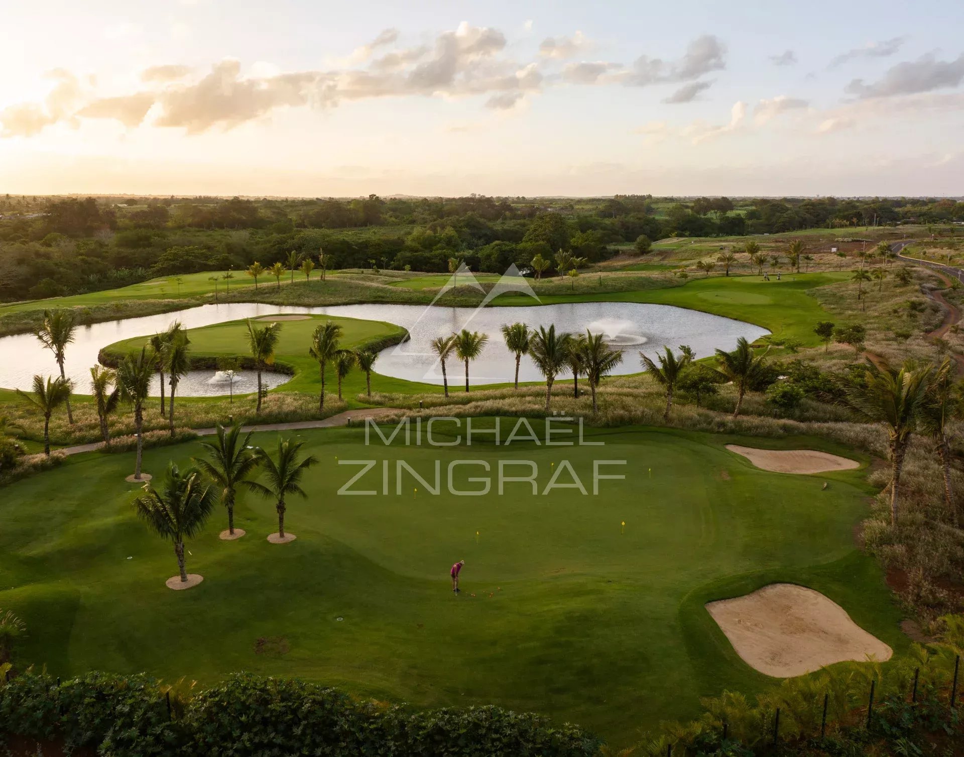 Vue panoramique d'un terrain de golf avec palmiers et plans d'eau à Azuri Golf and Beach Resort.